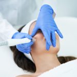 Beautiful young woman getting a face treatment at beauty salon.
